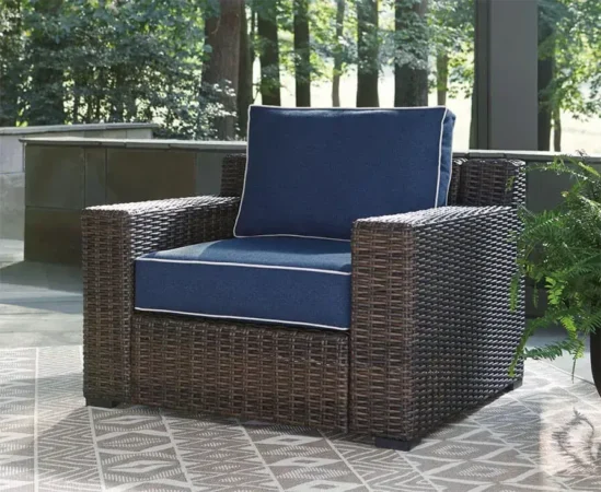 Wicker patio chair with blue cushions outdoors